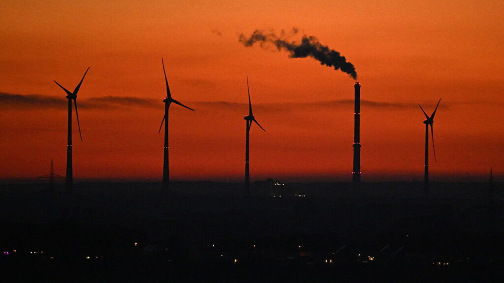Wind turbines next to an industrial chimney near Duisburg, western Germany