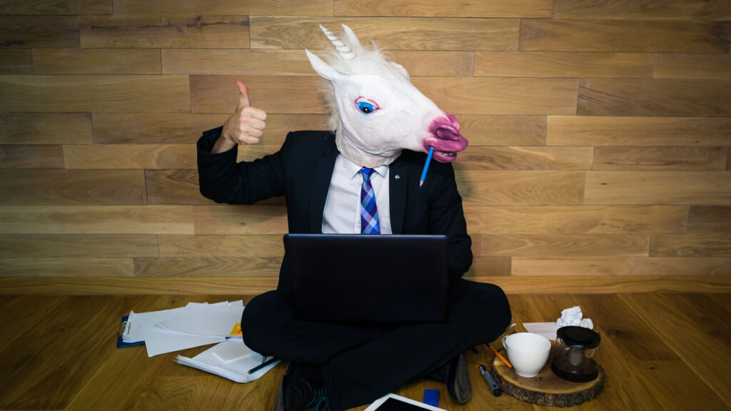 Business man wearing unicorn mask.