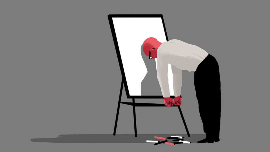 A business man putting his head against a whiteboard after a brainstorming session.