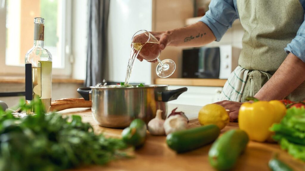 A chef cooks with wine