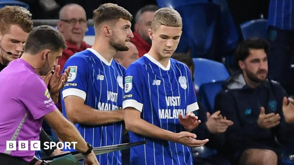 Axel Donczew (R) prepares to come on as a substitute for Cardiff against Newport