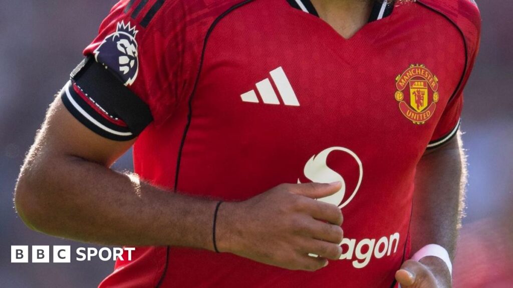 A Manchester United player wearing a black armband