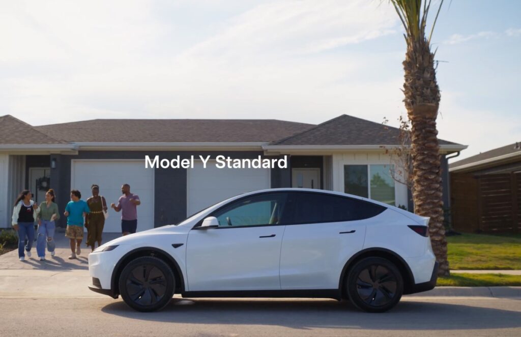 white Tesla Model Y parked in front of a house