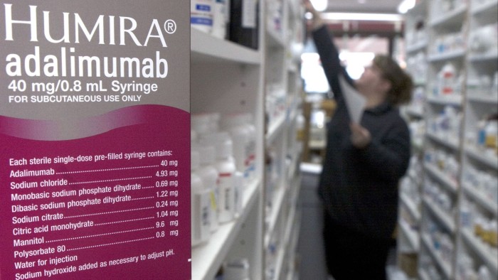 US set to speed up generic biological drug approvals A box of Humira (adalimumab) is shown in focus in a pharmacy, with shelves of medication and a person blurred in the background.