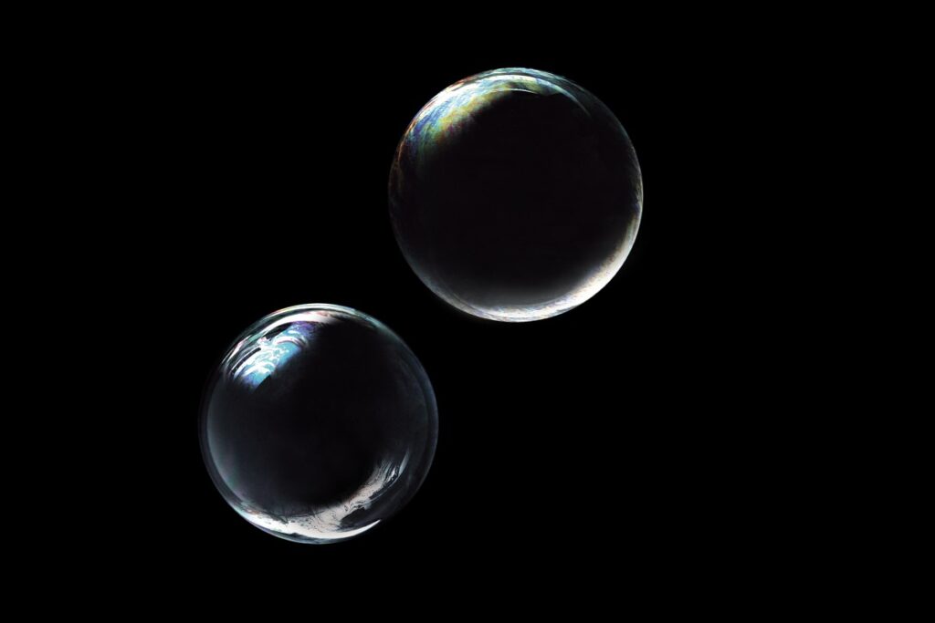 A better way of thinking about the AI bubble two bubbles floating against black backdrop