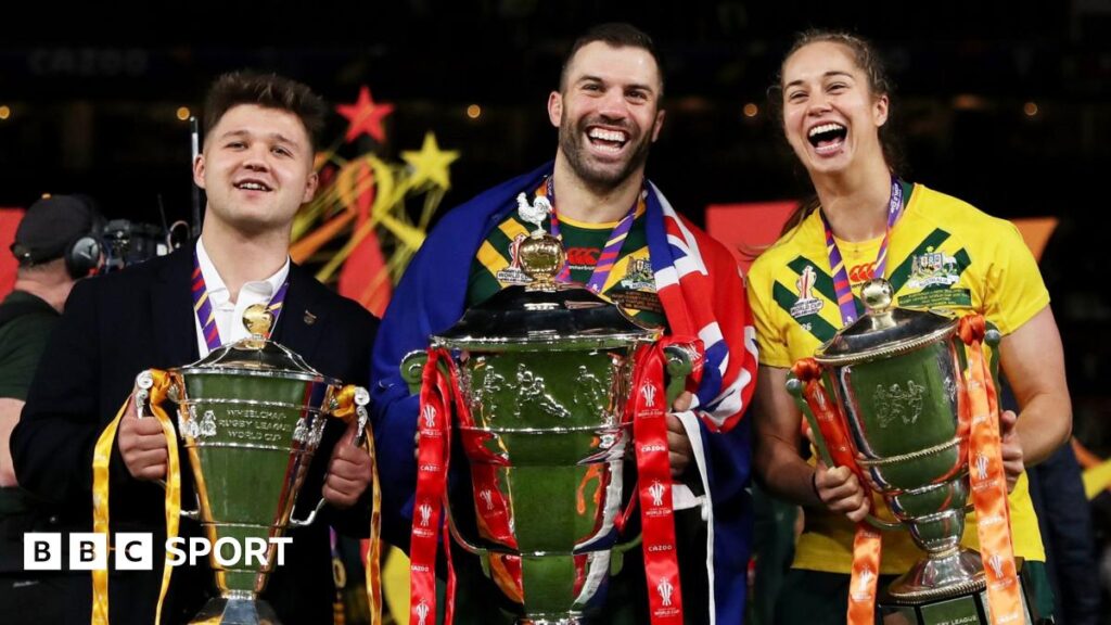 Tom Halliwell of England Wheelchair, James Tedesco of Australia and Kezie Apps of Australia pose for a photograph with their trophies after the Rugby League World Cup Final match between Australia and Samoa at Old Trafford on November 19, 2022