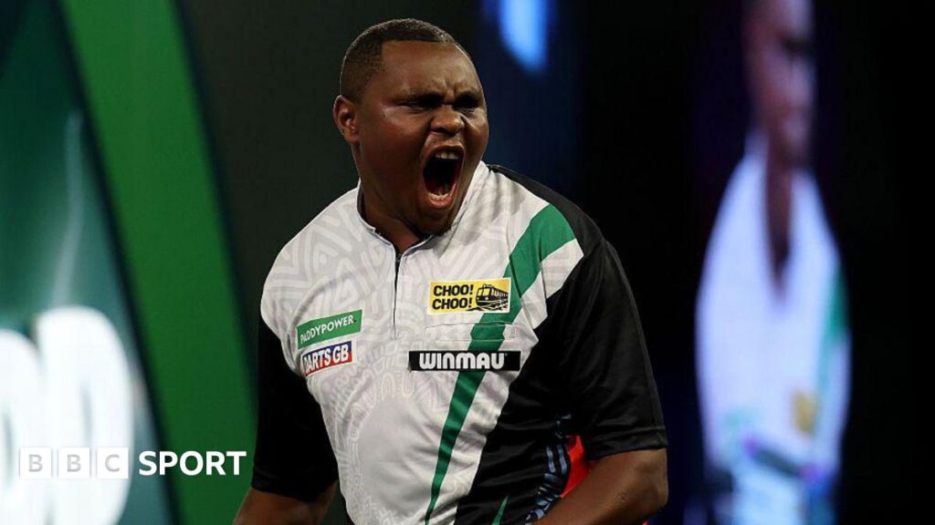 PDC World Darts Championship 2026: David Munyua stuns world number 18 Mike de Decker in first round David Munyua celebrates beating Mike de Decker