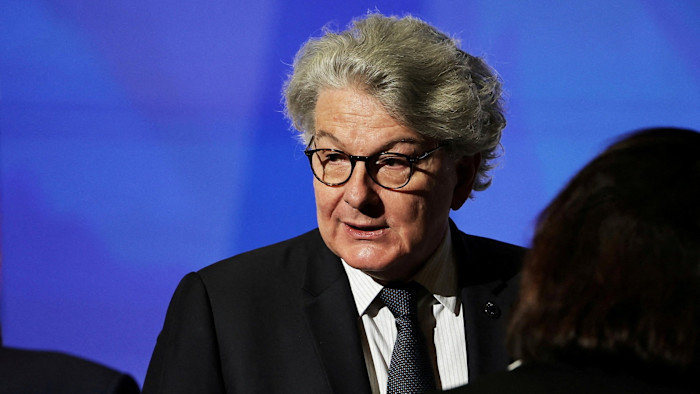 US bars former EU commissioner Thierry Breton and others over tech rules Thierry Breton listens with a serious expression, wearing a suit and glasses, in front of a blue background.