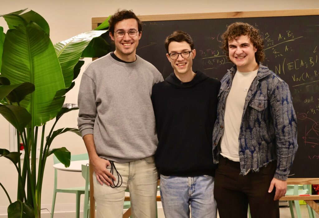 Flapping Airplanes on the future of AI: ‘We want to try really radically different things’ Three smiling men stand in front of a chalkboard